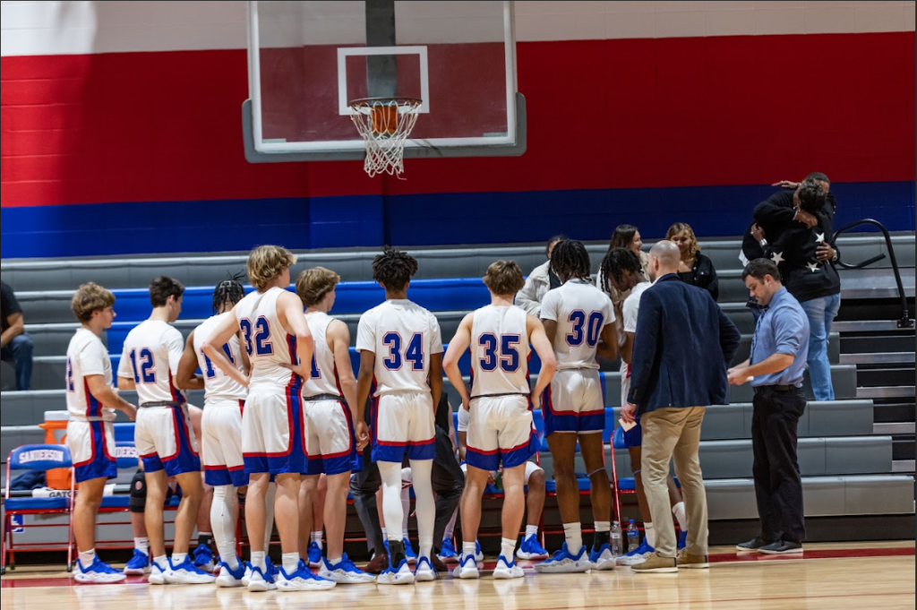The Sanderson High School boys basketball team in a huddle mid-game.
