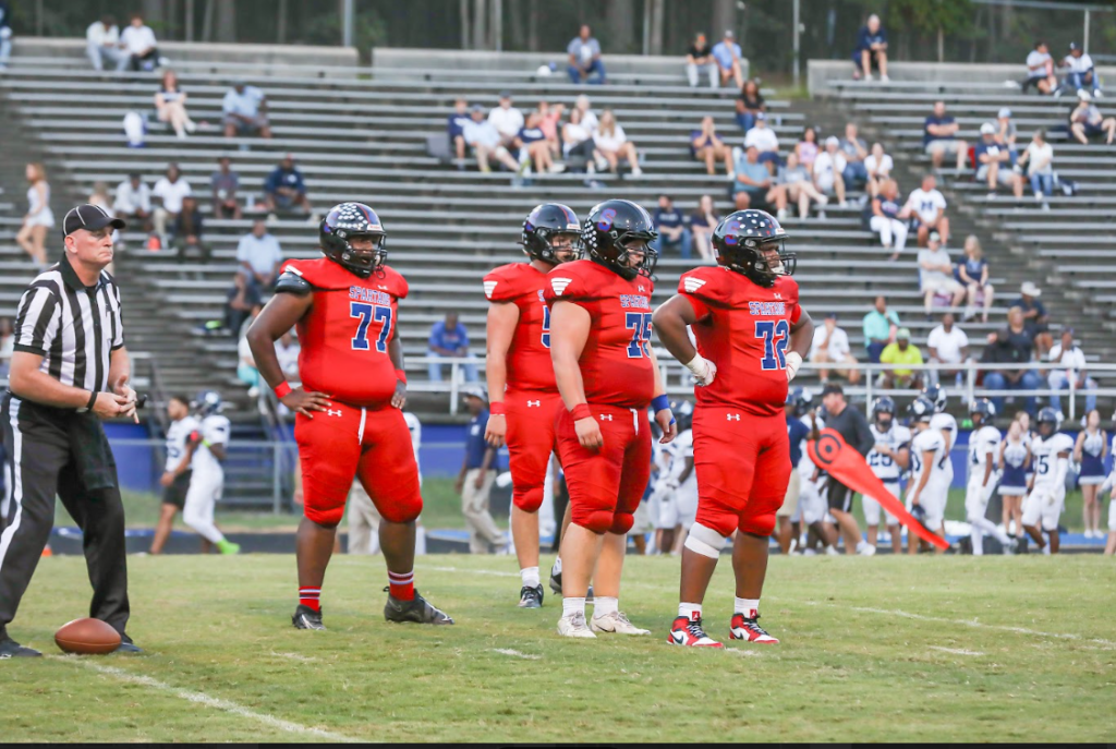 4 Sanderson High School football players standing before the game starts.